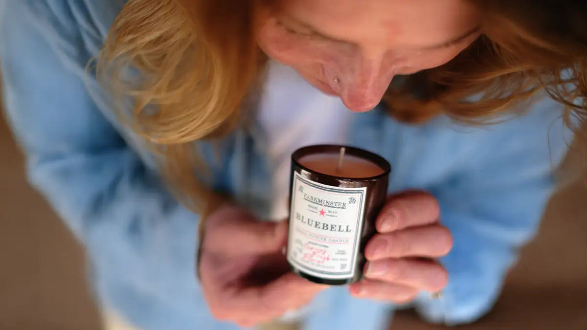 Person smelling Bluebell scented soy candle with fresh floral aroma, natural candle made with soy wax, reflecting local British home fragrance and clean botanical scent trends for 2026