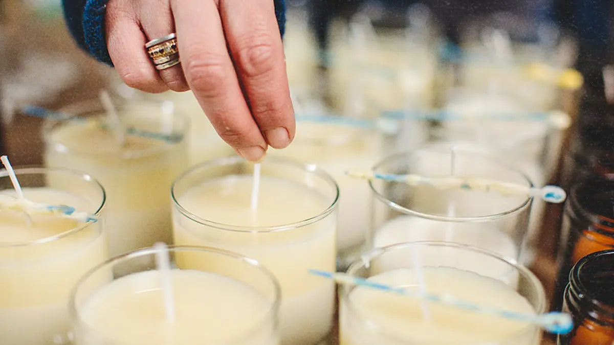 Carefully straightening wicks in freshly poured soy wax candle jars at Parkminster Home Fragrance Co, ensuring even, clean burning