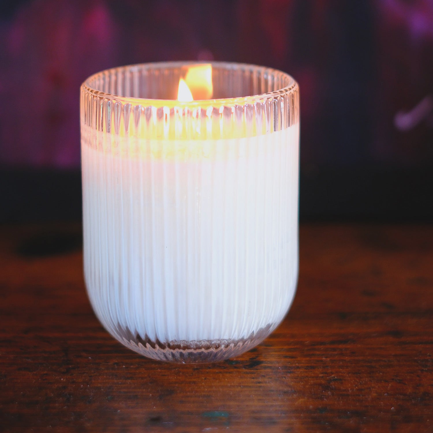 Pomegranate HÆFEN candle in ribbed glass with plum, patchouli, rose, vanilla, and cedarwood fragrance. Elegant glow and natural ambiance for your home.