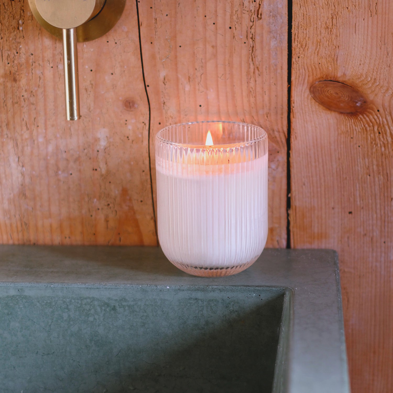 Parkminster Rhubarb HÆFEN Candle in ribbed glass, featuring a tart, fruity fragrance and a warm, glowing light for a refreshing home ambiance.