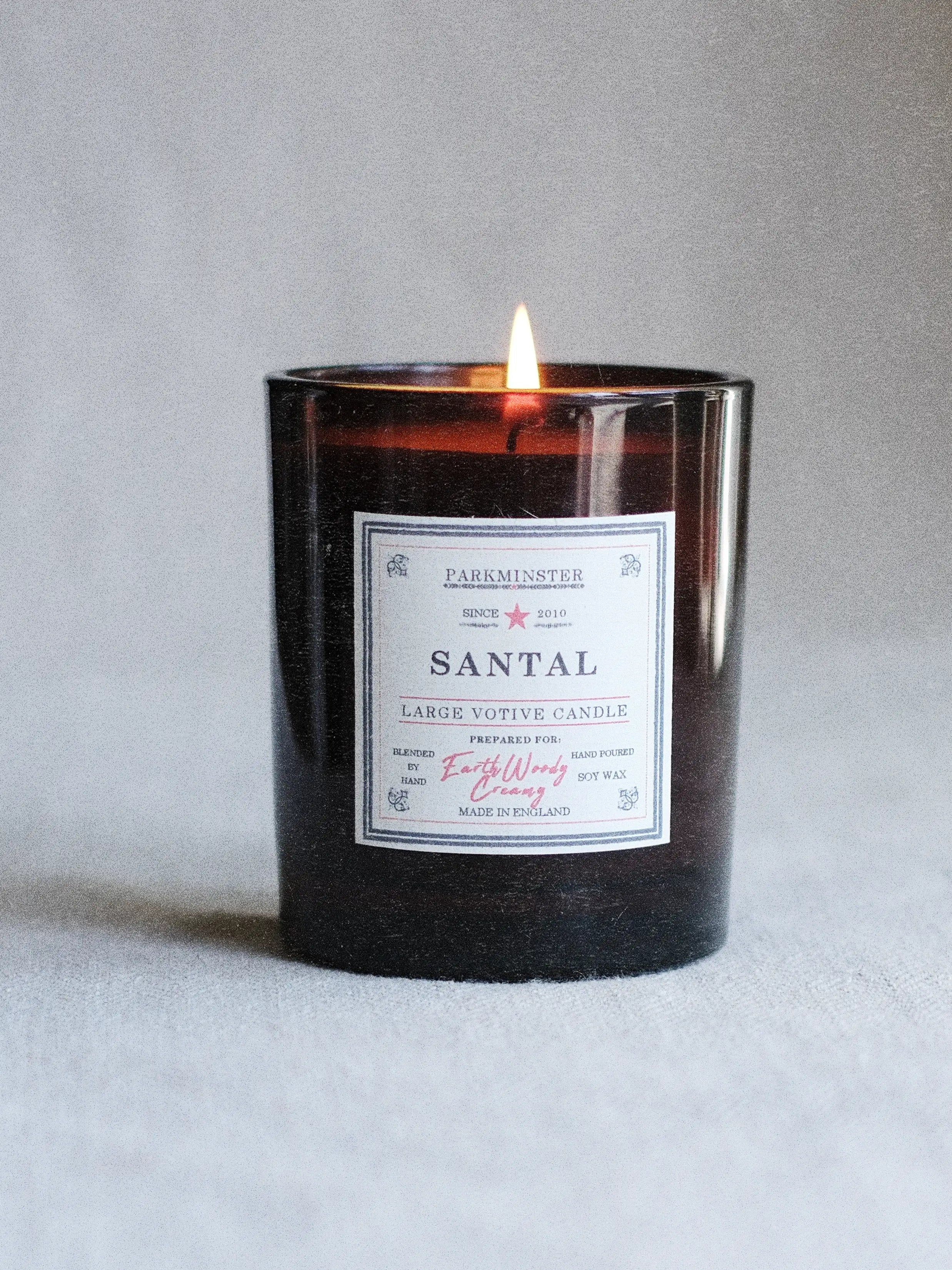 Parkminster Santal large votive candle in amber glass jar with natural soy wax and citrus woody cream fragrance notes in recyclable kraft packaging