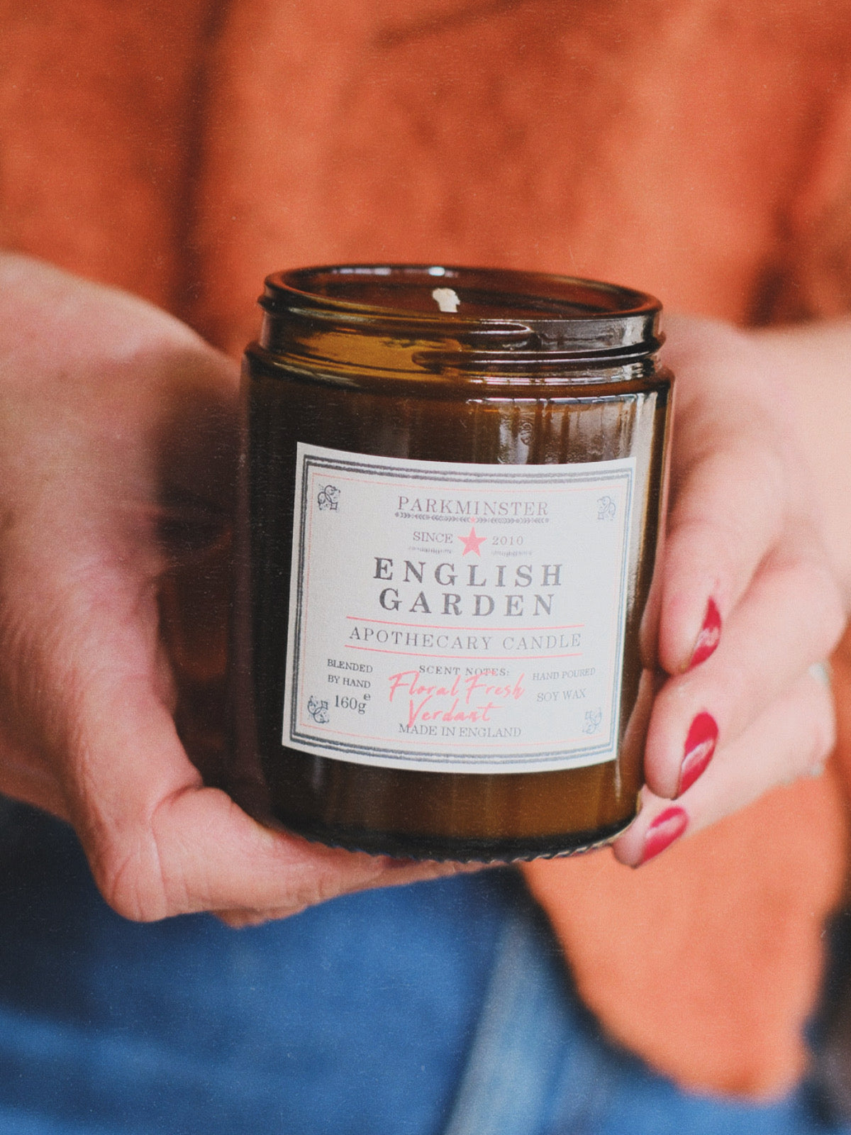A brown amber apothecary-style glass jar candle labelled ‘English Garden – Apothecary Jar Candle 
 by Parkminster Home Fragrance Co - Soy Wax Candle