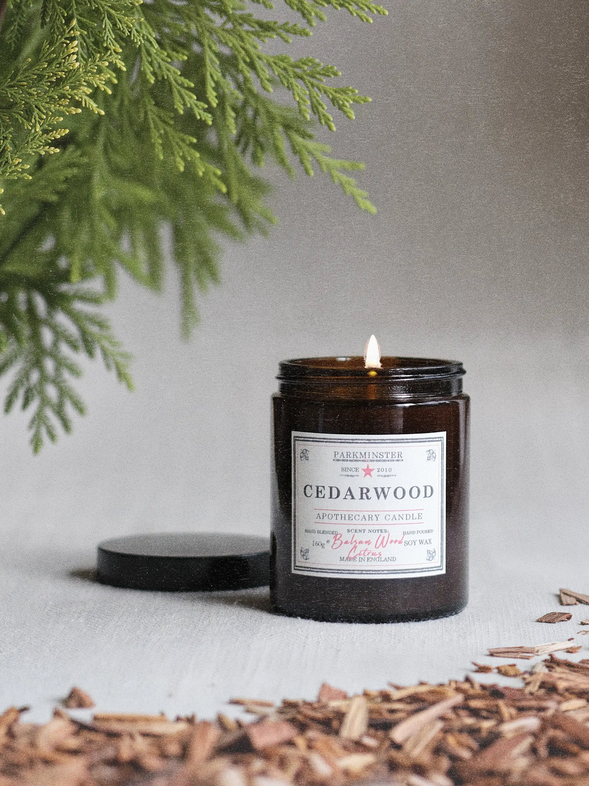Cedarwood essential oil candle in an amber apothecary glass jar with an earthy, citrus, woody aroma.
