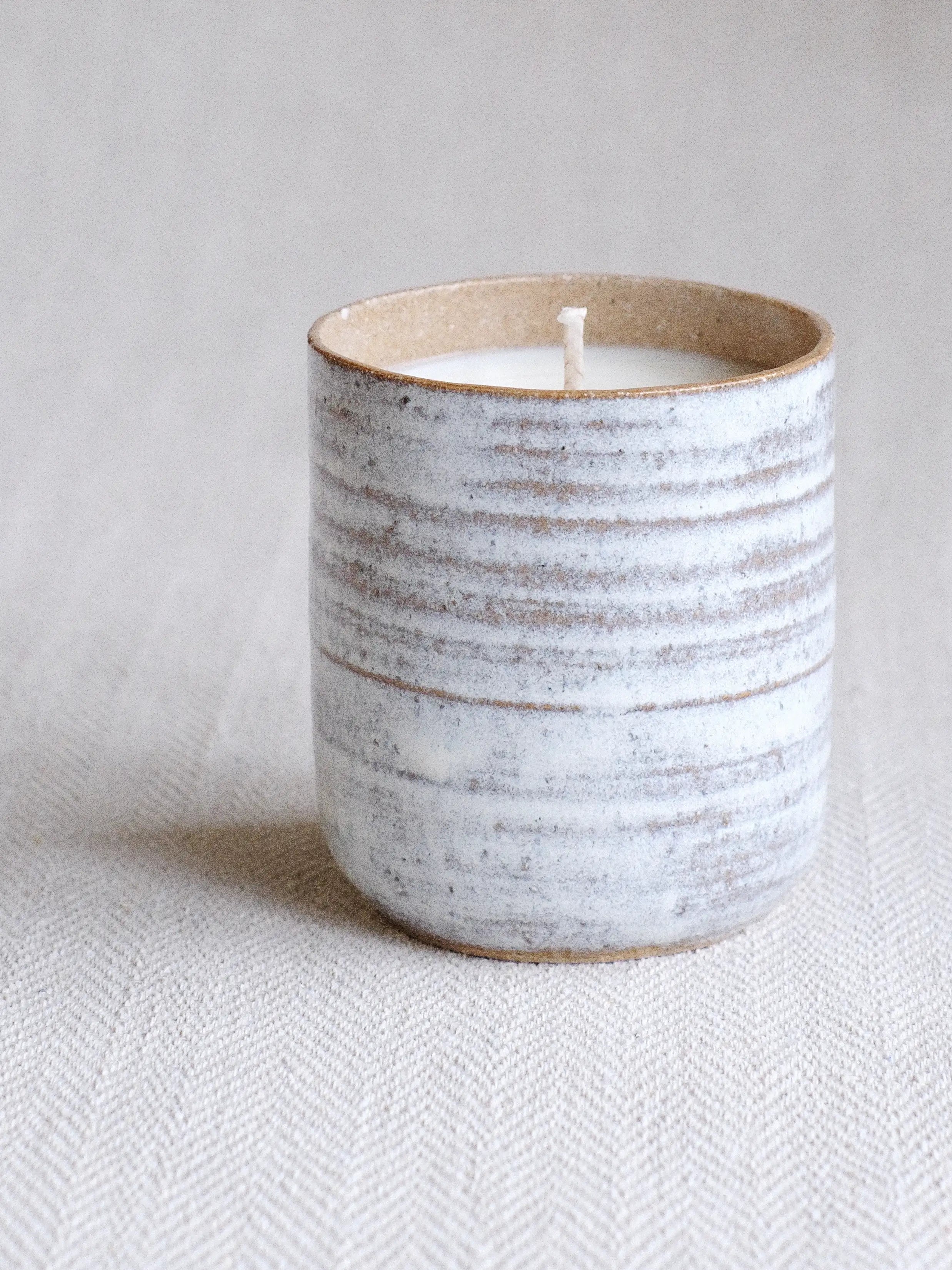 a Parkminster Kiln Collection soy wax candle in a blue grey ceramic pot by Jenna Bray Ceramics filled with natural Parkminster fragrances