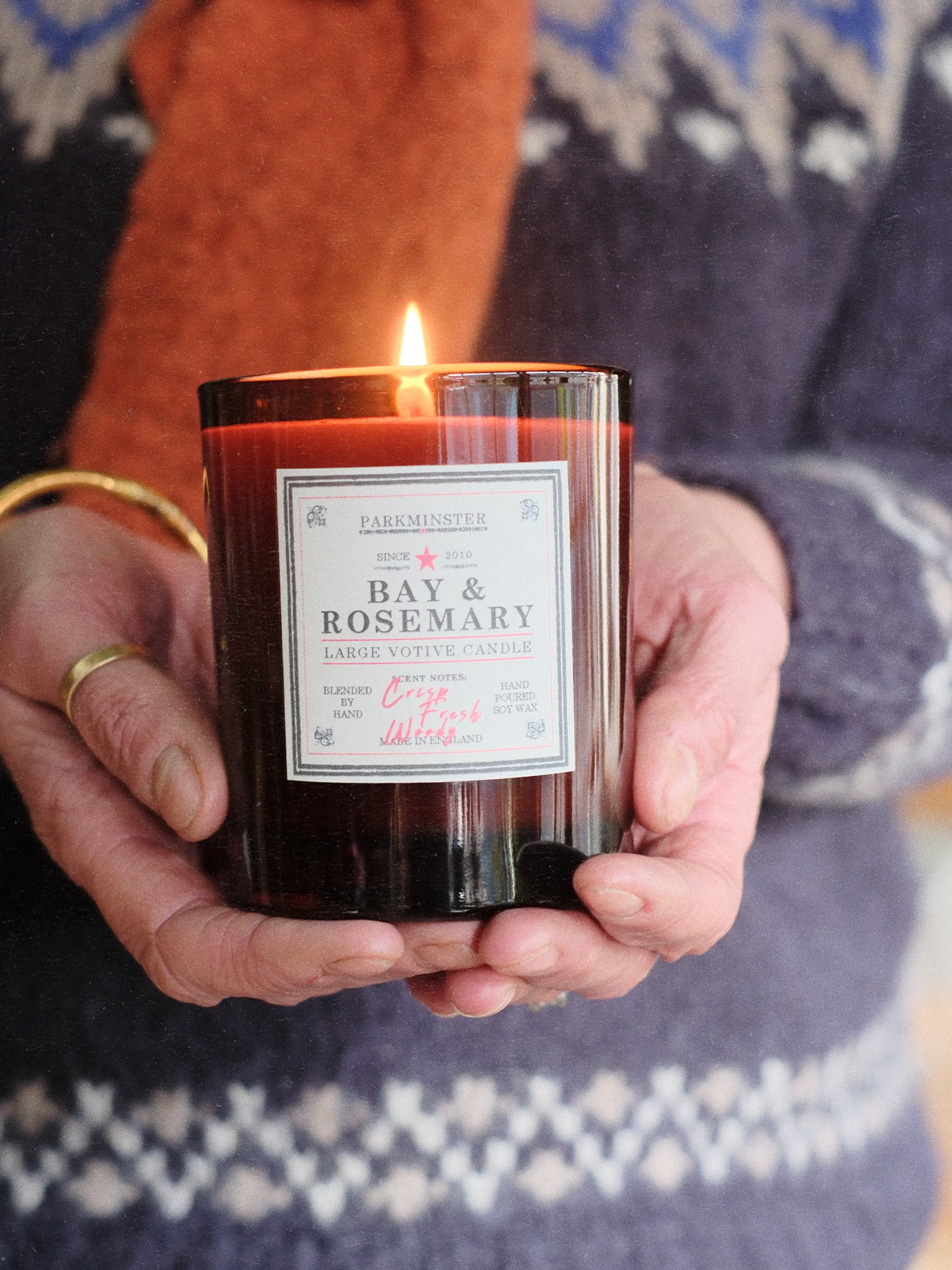 Person holding a Bay & Rosemary candle with a warm background - Parkminster essential oil candle