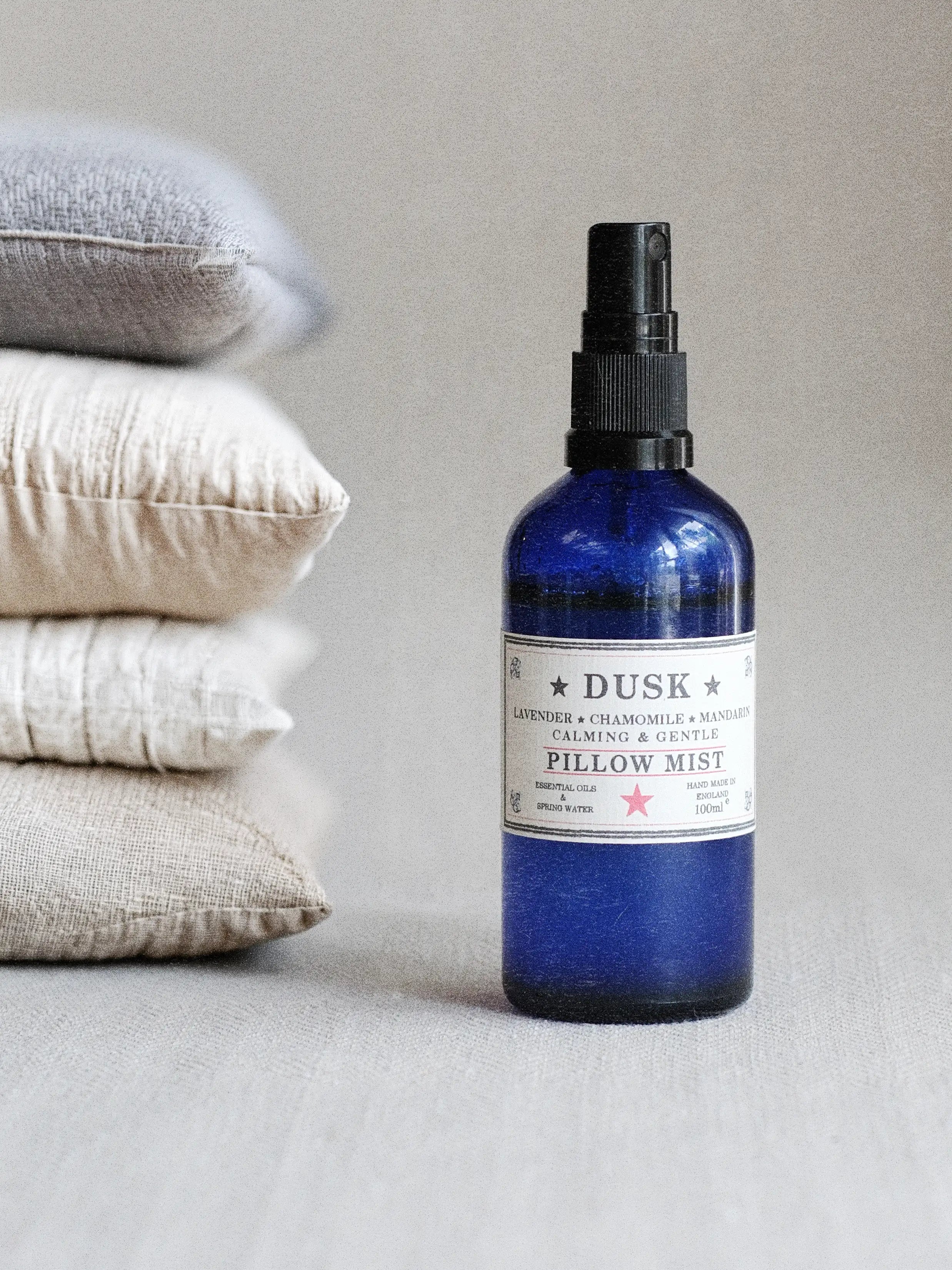 a Parkminster DUSK pillow mist with lavender, chamomile and mandarin essential oils creating a calming natural sleep spray beside a softly styled pillows