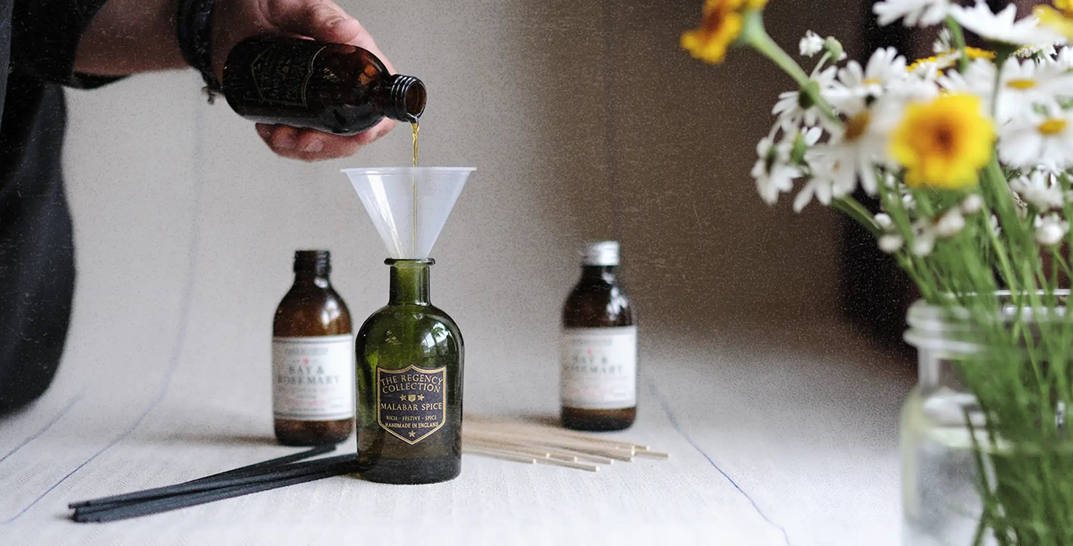 Parkminster 200ml Reed Diffuser Refill being poured into one of our luxury home fragrance diffuser bottles